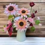 Vase of hand crafted flowers. Plum sunflowers, calla lilies, scabiosa and greenery.