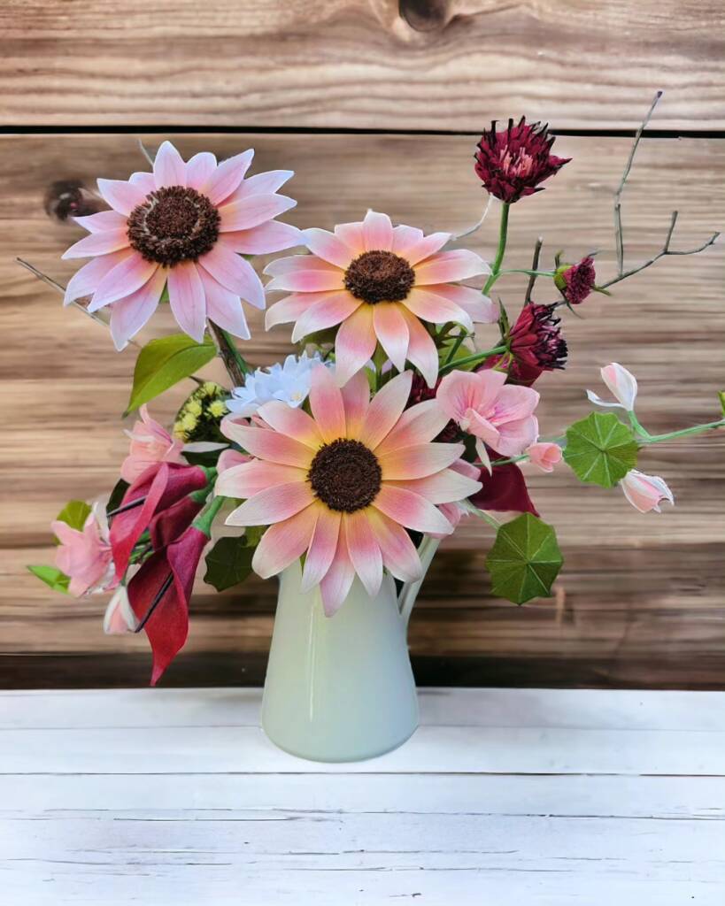 Vase of hand crafted flowers. Plum sunflowers, calla lilies, scabiosa and greenery.